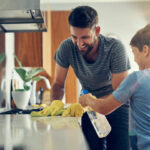 Shot of a father and son cleaning the kitchen counter together at home