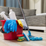Cleaning service. Bucket with sponges, chemicals bottles and mopping stick. Rubber gloves and towel. Household equipment.